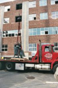 Historical statue of Abraham Lincoln at Manchester NH's Central High School is loaded onto a Louis P. Cote Inc flatbed truck for transport