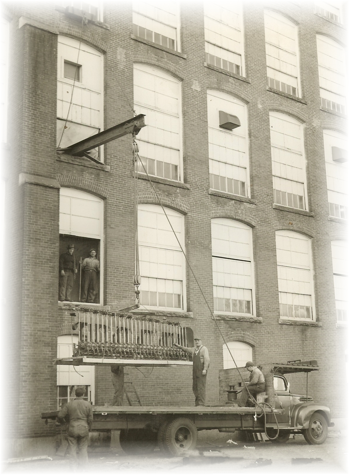 Louis P. Cote, Inc. utilizing rigging techniques to move textile machinery in Manchester NH's historic mill yards in the 1940s