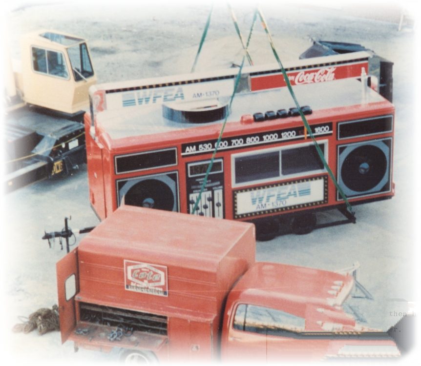 Louis P. Cote, Inc.'s crane prepares to lift a large promotional stand for an event in the 1980s
