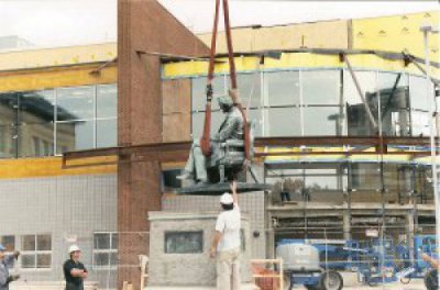 Riggers from Louis P. Cote, Inc. work with a crane operator to hoist a historical statue of Abraham Lincoln at Manchester NH's Central High School, as it's readied for transport.