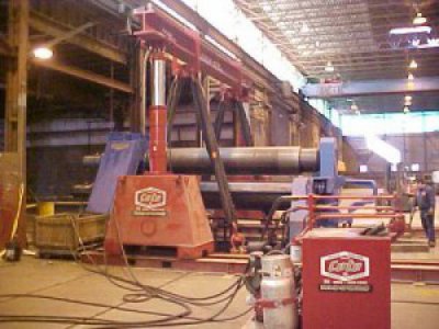 Louis P. Cote, Inc. riggers use a gantry system to lift heavy machinery in their Goffstown NH warehouse.