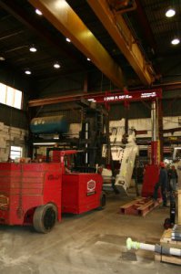 Louis P. Cote, Inc.'s riggers use a gantry system and Versa-Lift forklift to rotate a piece of heavy machinery in their Goffstown NH warehouse.