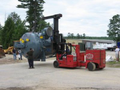 Louis P. Cote, Inc.'s riggers use a Versa-Lift forklift to unload a piece of heavy machinery at their Goffstown NH warehouse.