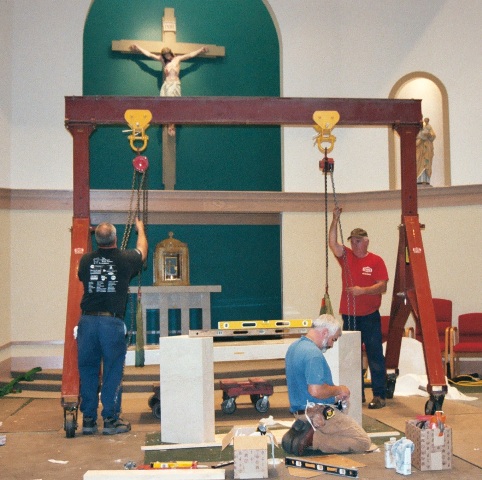 Louis P. Cote, Inc. riggers use an overhead pulley system to lift an altar for a local NH church