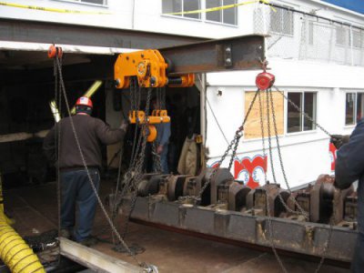 Louis P. Cote, Inc.'s riggers move the crankcase towards the dock inside of the MS Mount Washington Cruise Ship on Lake Winnipesaukee in Laconia NH
