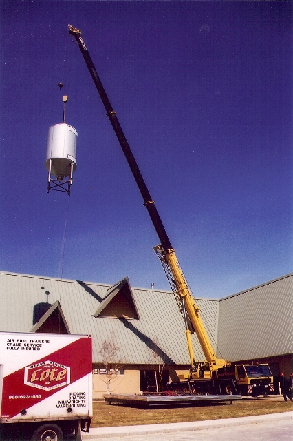 Louis P. Cote, Inc.'s riggers use a crane to hoist a large tank.